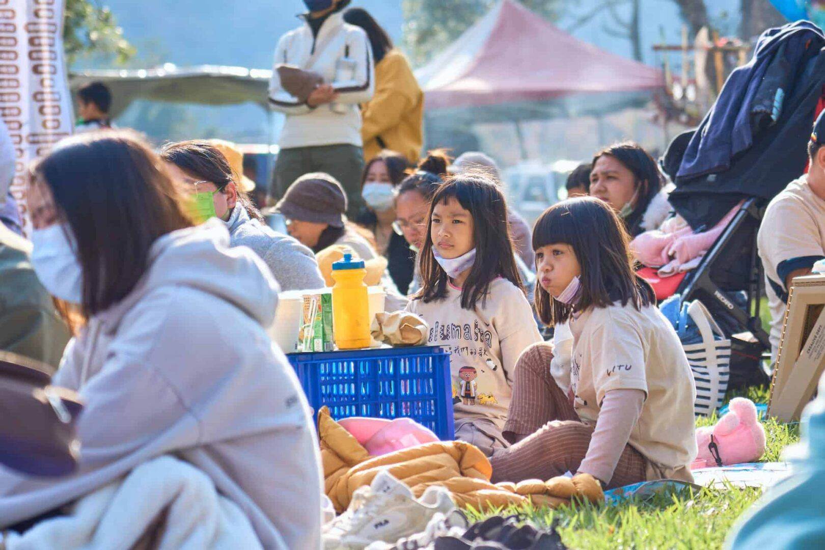 台東音樂節上，一群孩子坐在帳篷前的草地上。